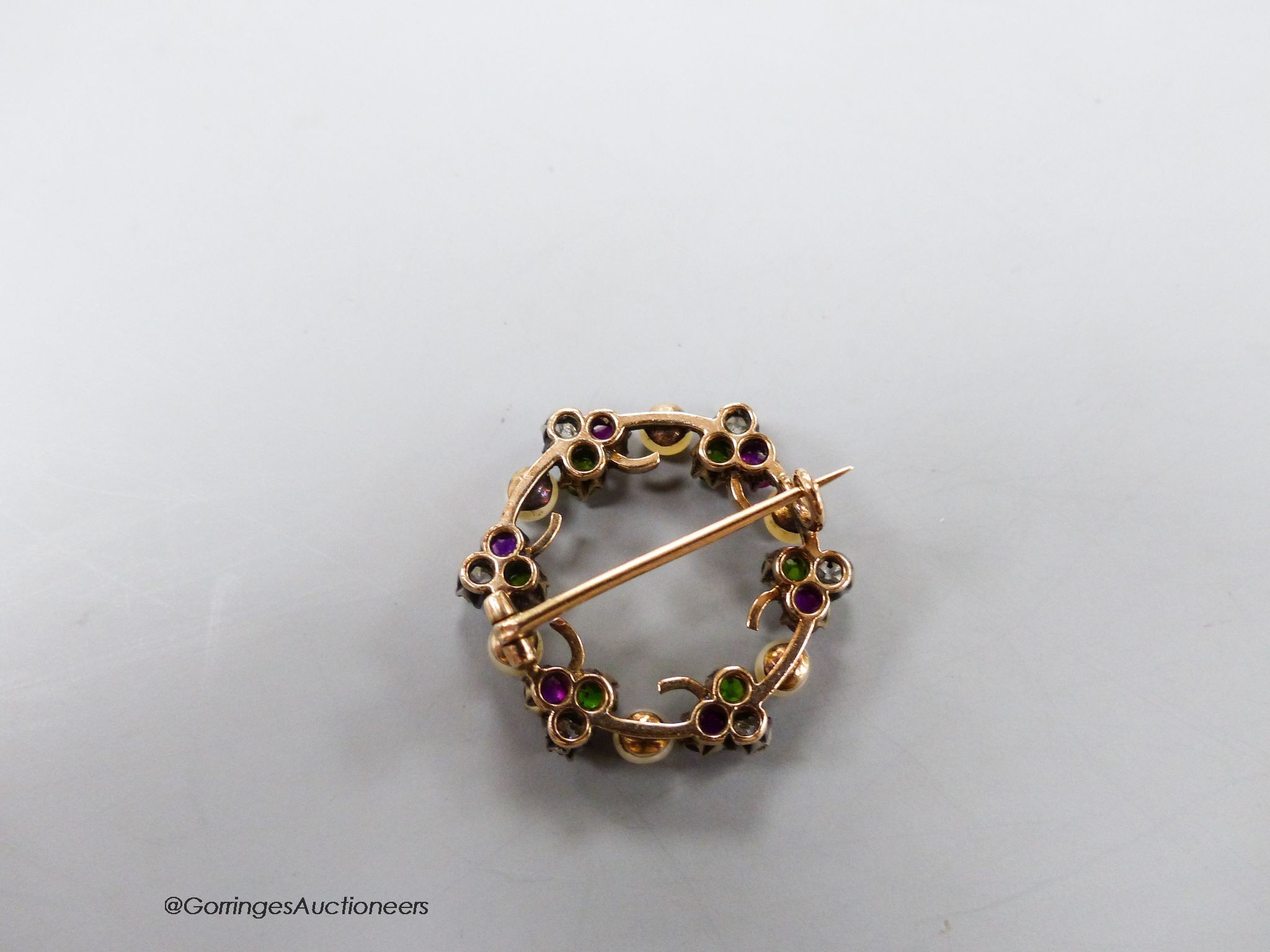 An early 20th century cultured pearl, garnet and diamond set clover cluster openwork brooch, 26mm, gross 6.3 grams.